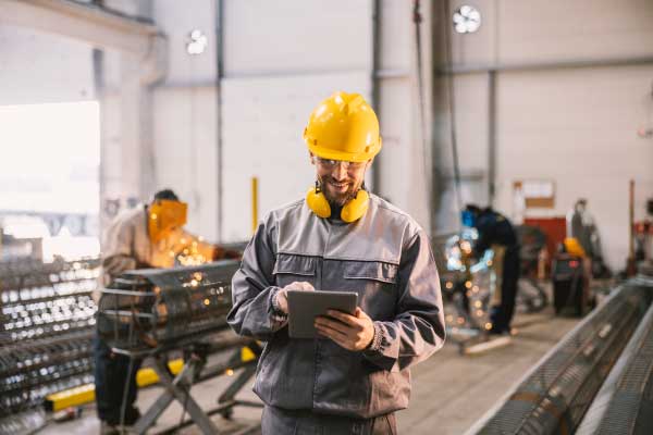 A supervisor is approving timesheet on tablet in workshop