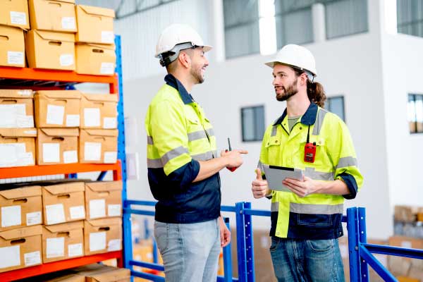 Two warehouse workers having a discussion about inventory management