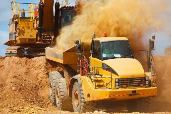 Excavator loading truck in quarry