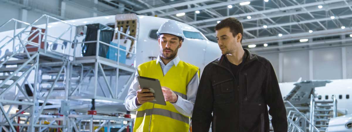 Aircraft mechanics using tablet in hanger